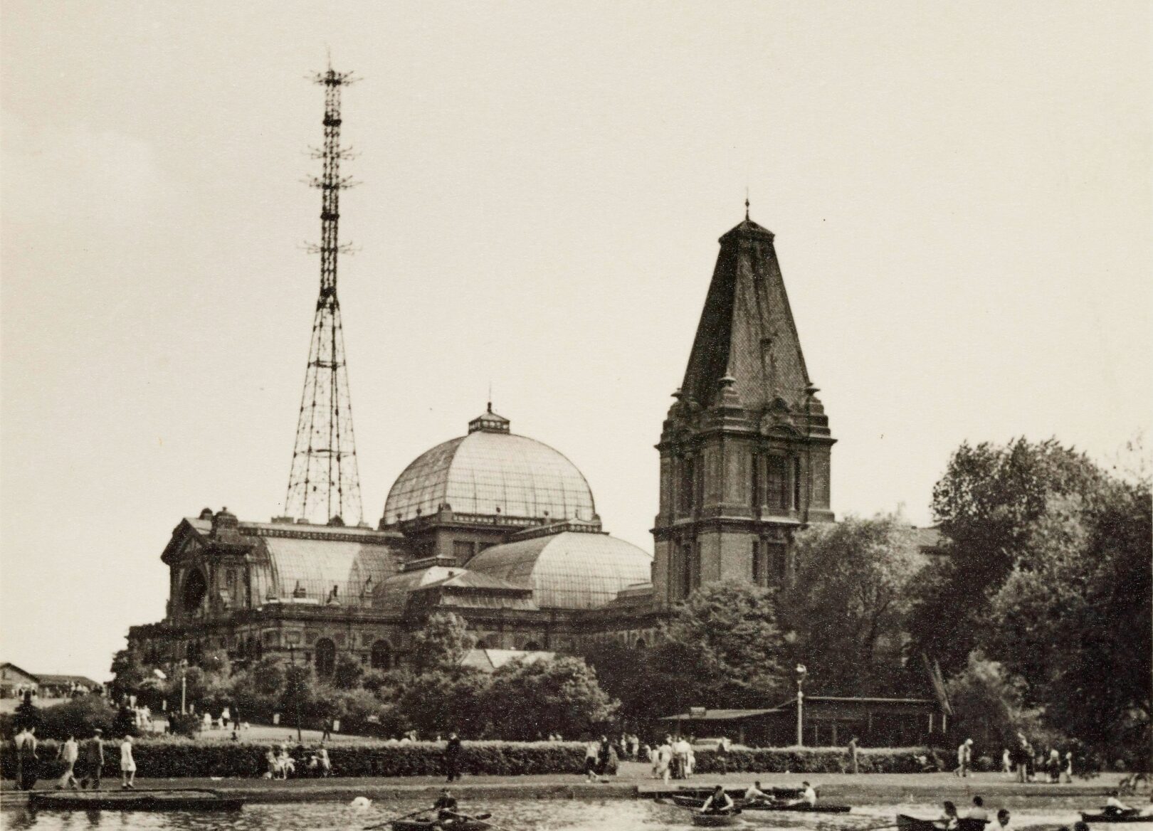 Vintage photograph of boating lake with Alexandra Palace in the background with a BBC TV mast on top of the building.