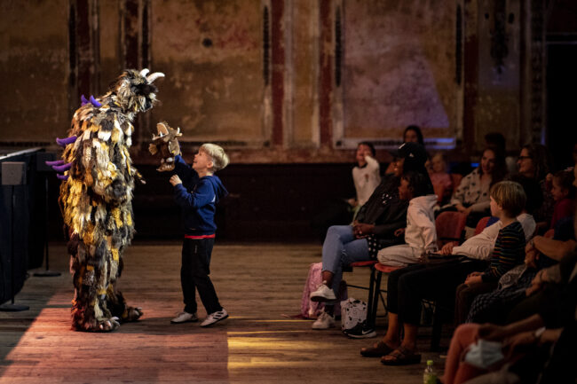Gruffalo performer with a child with a gruffalo hand puppet