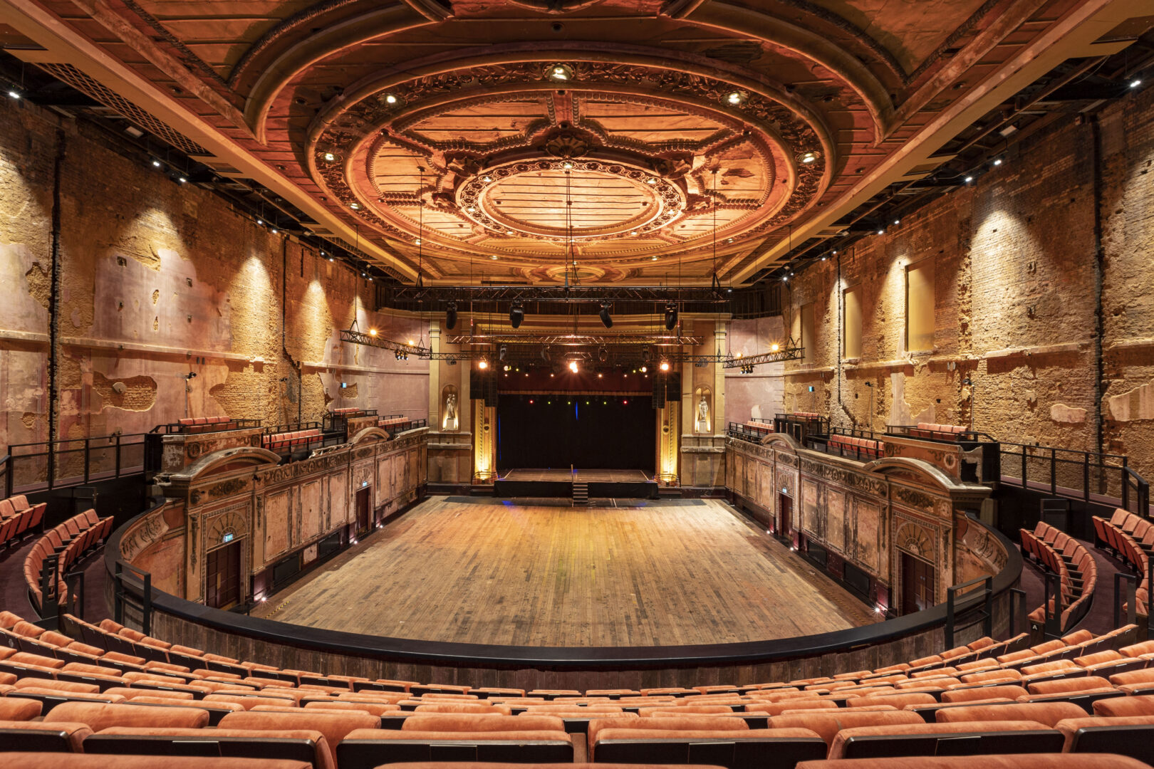 A grand empty theatre with orange seats,